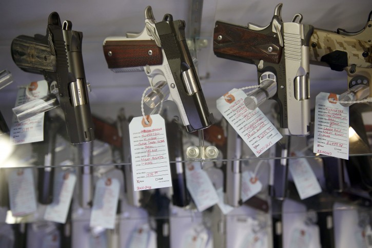 FILE - In this Nov. 15, 2014 file photo, handguns sit in a glass display case in Bridgeton, Mo. The FBI processed a record number of firearms background checks on Black Friday, the agency said Tuesday. (AP Photo/Jeff Roberson, File)