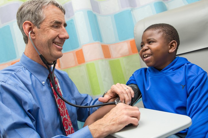In this photo provided by the University of Virginia Health System, taken Dec. 9, 2015, Marshall Jones, right, laughs with Dr. John Barcia in the Battle Building at the University of Virginia Children's Hospital in Charlottesville, Va. A shake-up of the nation's kidney transplant system is getting more organs to patients once thought nearly impossible to match, according to early tracking of the new rules. (Coe Sweet/UVA Health System via AP)