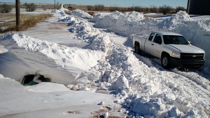 This Monday, Dec. 28, 2015 photo provided by Bill Kshir shows a buried Ford Fusion, left, outside of Clovis, N.M. a day after a record snow storm swept New Mexico. Jimmy and Betty Anderson, two newspaper carriers with Clovis Media, Inc., were buried in a 12-foot snow drift for nearly 20 hours until a tractor driver found them Sunday, Dec. 27. (Bill Kshir via AP)