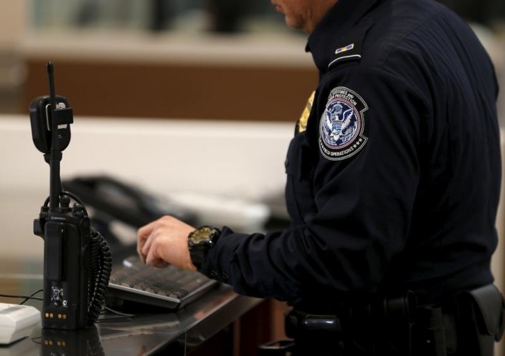 FILE - A U.S. Customs and Immigration officer works a new border crossing during the opening day of the Cross Border Xpress pedestrian bridge between San Diego and the Tijuana airport on the facility's opening day in Otay Mesa, California December 9, 2015.REUTERS