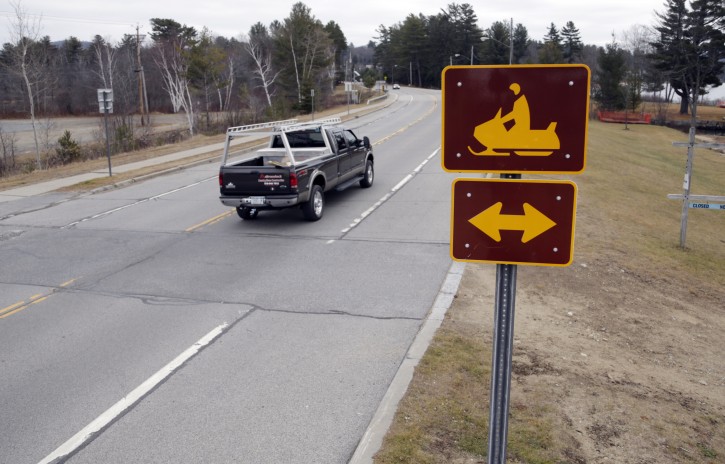 A snowmobile crossing sign is seen along Route 30 on Tuesday, Dec. 8, 2015, in Speculator, N.Y. Some Northeasterners are beginning to wonder if a white Christmas may just be a dream, and business owners who rely on snow are starting to worry if warm weather could lead to a nightmare winter. (AP Photo/Mike Groll)