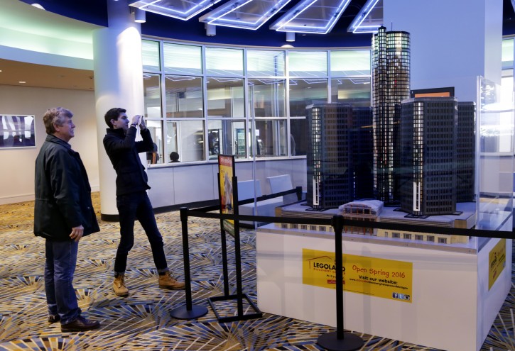 In this photo taken Monday, Jan. 18, 2016, Legos fan Cory Gordinier, 25. and his father Terry Gordinier, left, both of Ann Arbor, look at a replica of the Renaissance Center made out of Legos that is displayed at the Cobo Center during the North American International Auto Show in Detroit. (Romain Blanquart/Detroit Free Press via AP)  