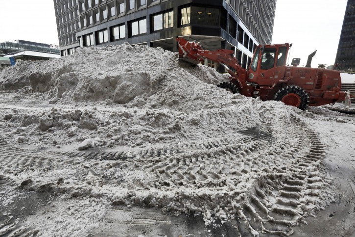 A New York City Dept. of Sanitation front end loader grooms snow in lower Manhattan, in New York  Monday, Jan. 25, 2016. East Coast residents clobbered by the weekend blizzard trudged into the workweek Monday amid slippery roads, spotty transit service and mounds of snow that buried cars and blocked sidewalks after some cities got an entire winter's snow in two days. (AP Photo/Richard Drew)