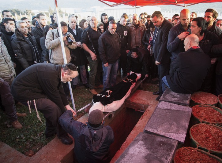 . Family and friends of Alon Bakal cry over his body during his funeral in the Northern Israeli city of Carmiel, on January 3, 2015. Flash90