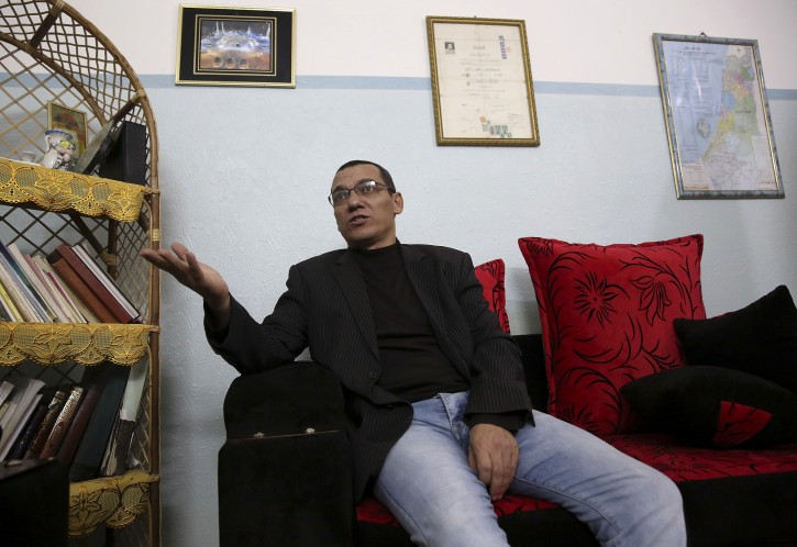 In this Tuesday, Jan. 12, 2016 photo, Palestinian journalist Ayman al-Aloul, 44, talks during an interview with the Associated Press, after being released from jail, at his family home in Gaza City. Al-Aloul frequently writes about the hardships engulfing the Gaza Strip, making him one of the few voices willing to publicly criticize the rule of the territorys Islamic Hamas movement. But after his nine-day stay in jail, al-Aloul says he wont be writing about politics anymore.  (AP Photo/Adel Hana)