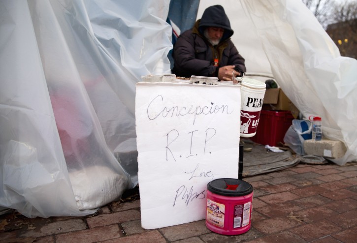 CraigThompson sits in the anti-nuclear-proliferation vigil stationed along Pennsylvania Avenue on the edge of Lafayette Square Park across from the White House in Washington, early Tuesday, Jan. 26, 2016. A white sign that reads "Concepcion RIP" leans against the front of the structure. Concepcion Picciotto, the protester who maintained a peace vigil outside the White House for more than three decades, a demonstration widely considered to be the longest-running act of political protest in U.S. history, has died. The Washington Post reports Picciotto died Monday, Jan. 25, 2016, at a housing facility for homeless women. She was believed to be 80. (AP Photo/Carolyn Kaster)