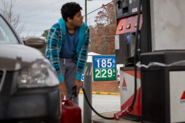 In this Wednesday, Nov. 25, 2015, photo, Cornelio Bonilla pumps gas at Best Food Mart gas station in Gainesville Ga. The price of oil continues to fall, extending a slide that has already gone further and lasted longer than most thought, and probing depths not seen since 2003. (AP Photo/Kevin Liles)