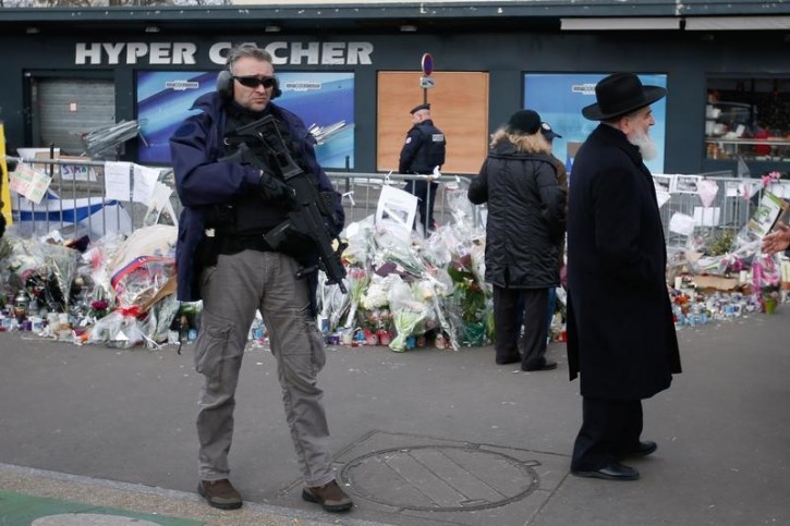 FILKE - A policeman stands guard in front of the Hyper Cacher kosher supermarket at the Porte de Vincennes in Paris January 21, 2015. Reuters