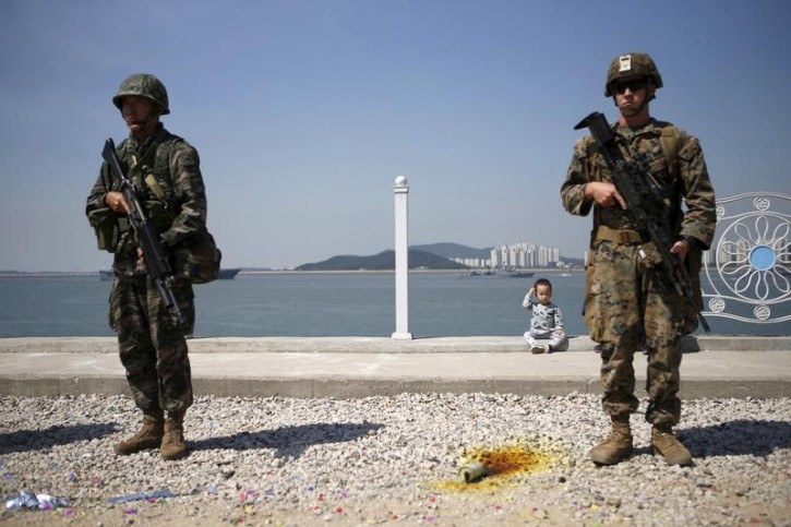 FILE - A boy sits between U.S. and South Korea marines during a ceremony to mark the 65th anniversary of Incheon Landing Operations conducted by the U.S.-led United Nations troop during the 1950-1953 Korean War, in Incheon, South Korea, September 15, 2015.   REUTERS/Kim Hong-Ji 