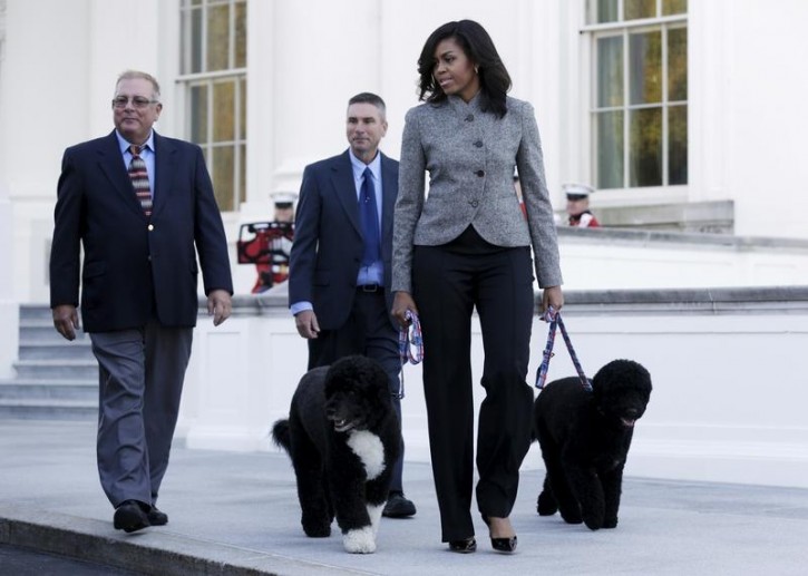 First Lady Michelle Obama walks with her dogs Bo and Sunny as she welcomes the Official White House Christmas Tree to the White House in Washington November 27, 2015. Reuters