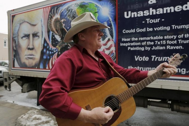 Kraig Moss tunes his guitar before performing his song about U.S. Republican presidential candidate Donald Trump in front of a truck featuring Trump in Des Moines, Iowa January 28, 2016.  REUTERS/Brian Snyder 