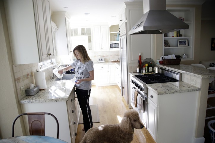 In this Friday, Jan. 15, 2016, photo, Therese Lehane stands in the kitchen of her home in San Jose, Calif. Lehane is renting out two of her rooms to Super Bowl news crews. In the San Francisco Bay Area, where high rents are legend, residents looking to make a quick buck are offering their homes at super-sized prices to the 1 million visitors expected for the Super Bowl festivities. (AP Photo/Marcio Jose Sanchez)