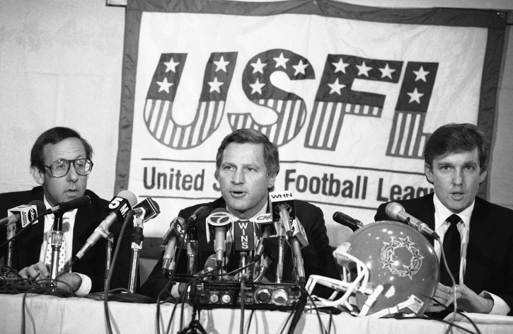 FILE - In this Aug. 2, 1985, file photo, Donald Trump, right, New York real estate magnates Stephen Ross, left, and USFL Commissioner Harry L. Usher, center, participate in a news conference in New York to discuss the agreement they have reached in principle to merge the Houston Gamblers and New Jersey Generals football franchises. The New Jersey Generals have been largely forgotten, but Trumps ownership of the team was formative in his evolution as a public figure and peerless self-publicist. With money and swagger, he led a shaky and relatively low-budget spring football league, the USFL, into a showdown with the NFL. (AP Photo/Marty Lederhandler, File)