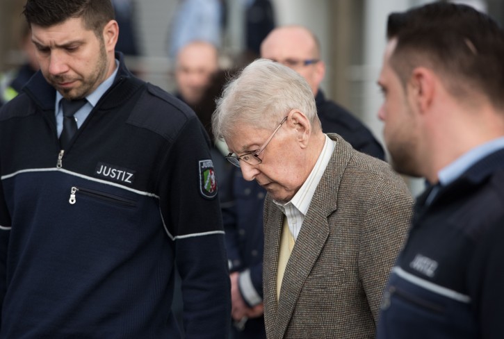 94-year-old former SS guard at the Auschwitz death camp Reinhold Hanning, center, leaves the building after the opening of his trial in Detmold, Germany, Thursday, Feb. 11, 2016. Hanning faces trial for 170,000 counts of accessory to murder, the first of up to four cases being brought to court this year in an 11th-hour push by German prosecutors to punish Nazi war crimes. (Bernd Thissen/Pool Photo via AP)