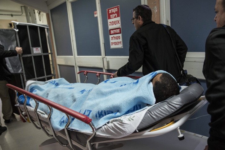 An Israeli soldier is wheeled through a hospital in Ashkelon, Israel, Sunday, Feb. 7, 2016. The soldier was stabbed in the torso near the central bus station in Ashkelon and the attacker was shot and apprehended, the police said. (AP Photo / Tsafrir Abayov)