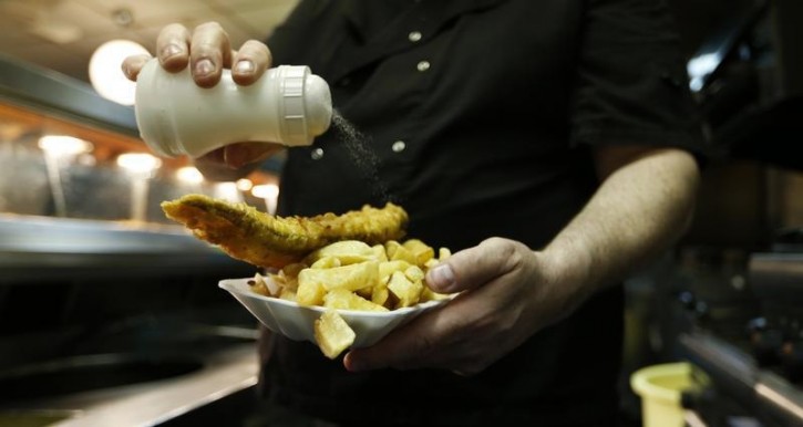 FILE  - Resturant Manager adds salt to a customer's fish and chips Reuters