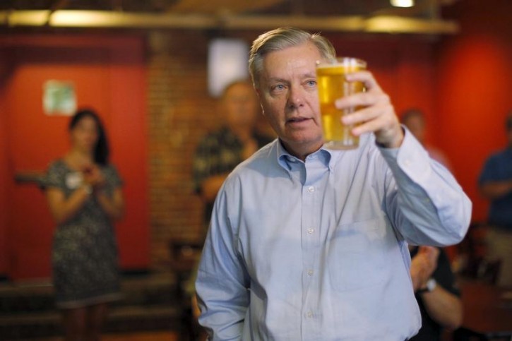 FILE - Fomer Republican presidential candidate and U.S. Senator Lindsey Graham holds up his beer after speaking during a campaign stop at Milly's Tavern in Manchester, New Hampshire, July 10, 2015. REUTERS/Brian Snyder 