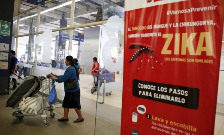 Travelers walk past a poster with information about the Zika virus during a campaign by Peru's Health Ministry at Plaza Norte bus station in Lima, Peru, February 4, 2016. REUTERS/Mariana Bazo 