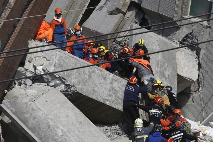 Rescuers carry a 20-year-old male survivor, identified by Taiwan media as Huang Kuang-wei, out from the site where a 17-storey apartment building collapsed after an earthquake hit Tainan, southern Taiwan February 7, 2016. REUTERS/Tyrone Siu   