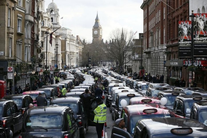 A police officer stands between rows of taxis during a protest by London cab drivers against Uber in central London, Britain February 10, 2016. REUTERS/Stefan Wermuth