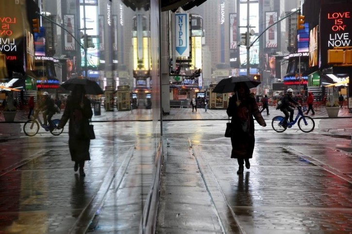 A woman walks with an umbrella in the rain at Times Square in New York February 24, 2016.  REUTERS/Shannon Stapleton 