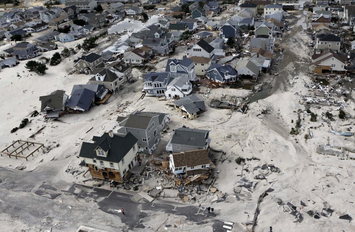 FILE - In this Oct. 31, 2012 file photo, a view from the air shows the destroyed homes left in the wake of Superstorm Sandy in Ortley Beach, N.J.  Sea levels on Earth are rising several times faster than they have in the past 2,800 years and are accelerating because of man-made global warming, according to new studies. An international team of scientists dug into two dozen locations across the globe to see what the sea level was for the past 2,800 years. They charted gently rising and falling seas over centuries and millennia. Until the 1880s and industrialization of society, on average the fastest seas rose was about 1 to 1.5 inches a century, plus or minus a bit. During that time global sea level really didnt get much higher or lower than three inches above or below the 2,000-year average.  (AP Photo/Mike Groll, File)