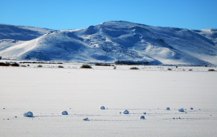 This Jan. 30, 2016 photo provided by The Nature Conservancy shows a rare weather event that caused the spontaneous snowballs at The Nature Conservancys Silver Creek Preserve and surrounding fields near the tiny town of Picabo, Idaho. The National Weather Service says snow rollers are caused by an unusual combination of snowfall around a couple inches with the right water density and temperatures near freezing followed by strong winds. (Sunny Healey/The Nature Conservancy via AP)