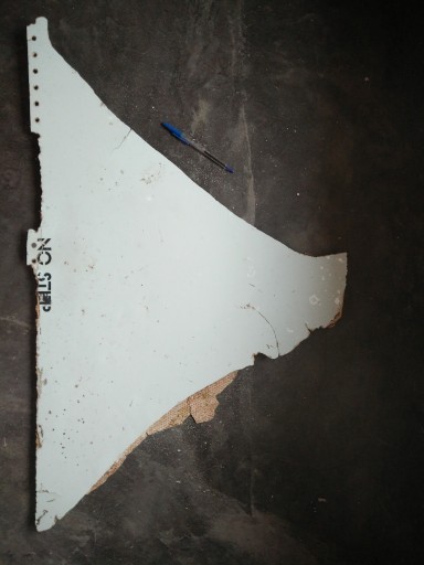In this Feb. 28, 2016 image provided by Blaine Gibson and the Australian Transport Safety Bureau (ATSB), a piece of aircraft debris with the words "NO STEP" on it is photographed after it was found washed up on a beach in Mozambique. Debris that washed up in Mozambique has been tentatively identified as a part from the same type of aircraft as the missing Malaysia Airlines Flight 370, a U.S. official said (Blaine Gibson/ATSB via AP)