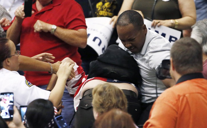 A supporter of Republican presidential candidate Donald Trump, right, scuffles with a protester as Trump speaks during a campaign rally Saturday, March 19, 2016, in Tucson, Ariz. (AP Photo/Ross D. Franklin)