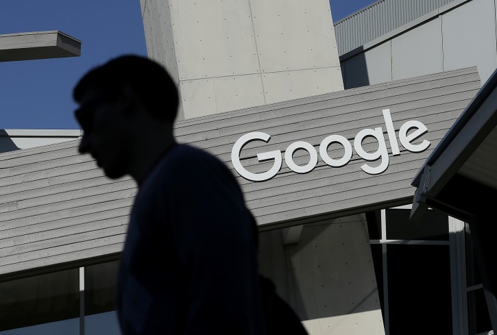 FILE - In this Nov. 12, 2015, file photo, a man walks past a building on the Google campus in Mountain View, Calif. (AP Photo/Jeff Chiu, File)