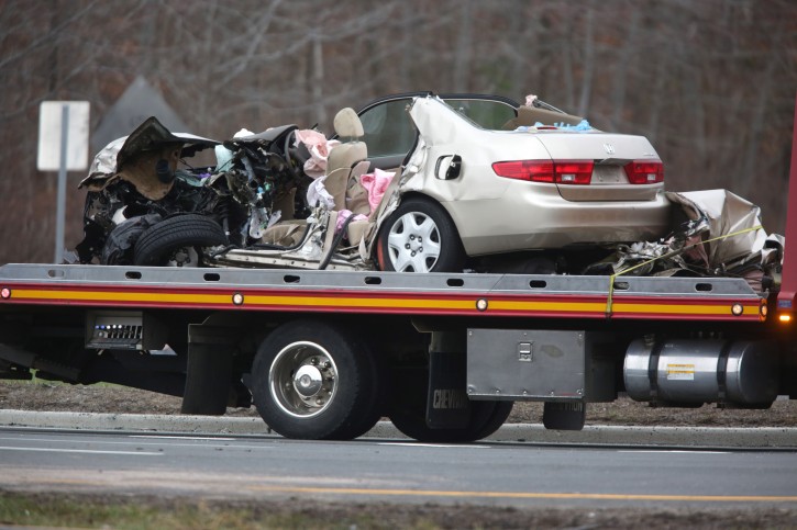 A vehicle is towed away after a fatal accident on Route 9 near Route 516 in Old Bridge, N.J., Tuesday, March 15, 2016. Authorities say a two-vehicle crash on a major New Jersey roadway has left multiple people dead and others seriously injured. (John O'Boyle /NJ Advance Media via AP)