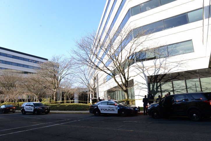 Police investigate the scene where a body was found on the grassy area in the rear of the Glenpointe business complex Tuesday, March 29, 2016, in Teaneck, N.J. (Tariq Zehawi /The Record of Bergen County via AP) 