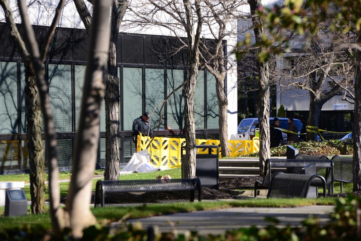 Police investigate the scene where a body was found on the grassy area in the rear of the Glenpointe business complex Tuesday, March 29, 2016, in Teaneck, N.J. (Tariq Zehawi /The Record of Bergen County via AP)