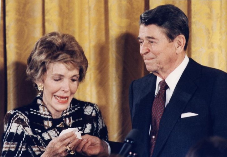 FILE - Reagan is pictured handing a hankerchief to former first lady Nancy Reagan during a farewell party given by the White House staff, in this January 18, 1988 file photo. REUTERS/Leighton Mark