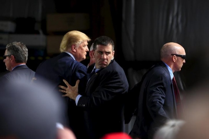 Secret Service agents surround U.S. Republican presidential candidate Donald Trump during a disturbance as he speaks at Dayton International Airport in Dayton, Ohio March 12, 2016. REUTERS/Aaron P. Bernstein 