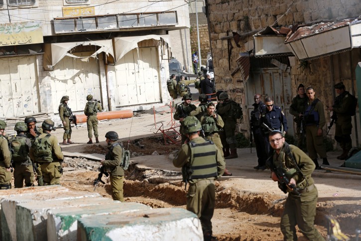  Israeli soldiers gather at the scene of a shooting near the Ibrahimi mosque in the West Bank old city of Hebron, 19 March 2016. Israeli soldiers shot dead a Palestinian who allegedly attempted to stab a soldier, the army said.  EPA/ABED AL HASHLAMOUN