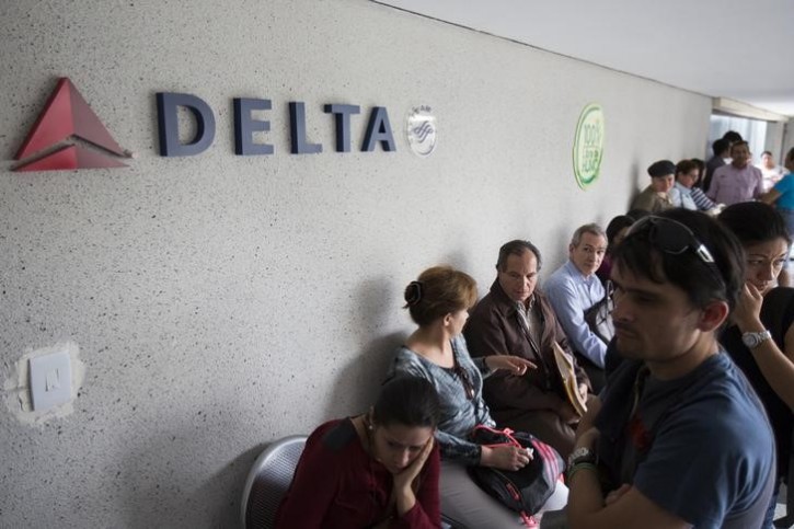 Customers wait their turn to be served in a line at the Delta airlines office in Caracas July 7, 2014. REUTERS/Carlos Garcia Rawlins
