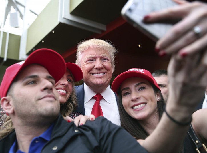 Supporter Pat Montelli, left, and friend Catherine Freeman, right, take a photograph with Republican presidential candidate Donald Trump at a campaign rally Sunday, April 17, 2016, in the Staten Island borough of New York. (AP Photo/Mel Evans)