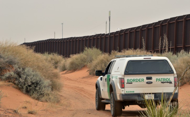 FILE - In this Jan. 4, 2016 file photo, a U.S. Border Patrol agent drives near the U.S.-Mexico border fence in Santa Teresa, N.M. A new complaint says U.S. Border Patrol agents are looting immigrants of possessions before deporting them to Mexico without their IDs or money. The ACLU of New Mexico and a coalition of advocacy groups filed the administrative complaint with the U.S. Department of Homeland Security on Wednesday, April 6, 2016, and say the seizures are endangering migrants at the U.S.-Mexico border. (AP Photo/Russell Contreras, File)