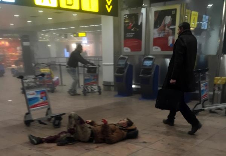 In this photo provided by Georgian Public Broadcaster and photographed by Ketevan Kardava, an injured man lies on the floor in Brussels Airport in Brussels, Belgium, after explosions were heard Tuesday, March 22, 2016. (Ketevan Kardava/ Georgian Public Broadcaster via AP)