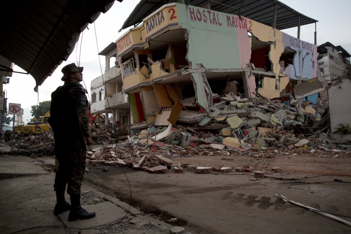 An air force soldier stands guard in front of buildings collapsed by an earthquake in Manta, Ecuador, Monday, April 18, 2016. A Saturday night quake left a trail of ruin along Ecuadors Pacific Ocean coast. Hundreds died and thousands are homeless. (AP Photo/Rodrigo Abd)