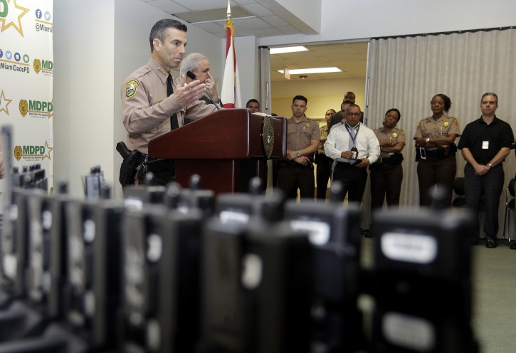 Miami-Dade Police Department Director Juan Perez talks about the department's plan to outfit 1,000 of its officers with body cameras, shown in the foreground, during a news conference, Thursday, April 28, 2016, in Doral, Fla. Police body cameras have become more popular following a number of controversial officer shootings around the country. (AP Photo/Lynne Sladky)