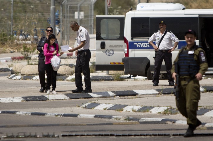 Palestinian 12-year-old Dima al-Wawi, who was imprisoned by Israel for allegedly attempting to carry out a stabbing attack, is escorted by Israeli border police officers and soldiers, after her release from an Israeli prison, at Jabara checkpoint near the West Bank town of Tulkarem, Sunday, April 24, 2016. Al-Wawi who was imprisoned after she confessed to planning a stabbing attack in a West Bank settlement has been released Sunday. (AP Photo/Majdi Mohammed)