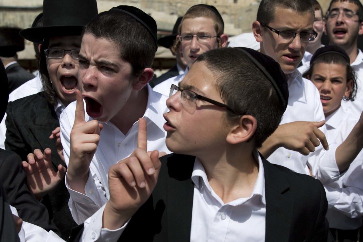 Ultra-Orthodox Jewish youth yell at a journalist covering the Jewish women's prayer during the Jewish holiday of Passover in front of the Western Wall, the holiest site where Jews can pray, in Jerusalem's Old City, April 24, 2016. A liberal women's group has held a special Passover prayer service at a Jerusalem holy site, drawing criticism from the site's ultra-Orthodox rabbi, who called it a "provocation." (AP Photo/Ariel Schalit)