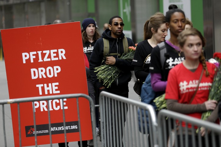 Activists line up to put flowers in crib in front of Pfizer world headquarters in New York, Wednesday, April 27, 2016. The crib filled with flowers, organized by Doctors Without Borders, was delivered to Pfizer with a petition demanding that the pharmaceutical company lower the cost of the pneumonia vaccine. (AP Photo/Seth Wenig)