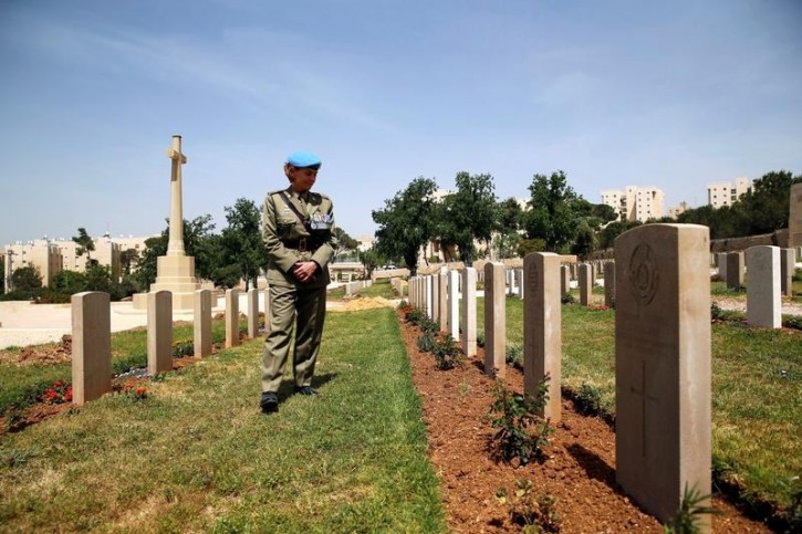 A military officer looks at gravestones after the annual ANZAC Day memorial ceremony at the Commonwealth War Graves Cemetery in Jerusalem April 25, 2016. REUTERS/Ammar Awad