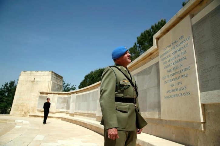 An officer reads inscriptions on a wall of remembrance after the annual ANZAC Day memorial ceremony at the Commonwealth War Graves Cemetery in Jerusalem April 25, 2016. REUTERS/Ammar Awad 