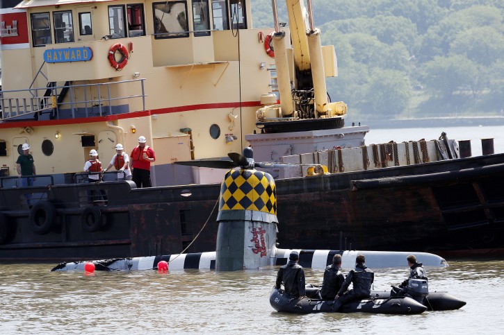 Officials remove a plane out of the Hudson River a day after it crashed, Saturday, May 28, 2016, in North Bergen, N.J. The World War II vintage P-47 Thunderbolt aircraft crashed into the river Friday, May 27, 2016, killing its pilot. (AP Photo/Julio Cortez)