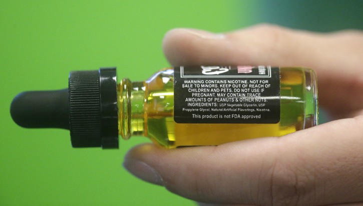 FILE - This Aug. 14, 2014, file photo shows a child-proof refill bottle of liquid nicotine in Salt Lake City. Electronic cigarettes have sickened rising numbers of young children, a study of U.S. poison center calls has found. Most cases involve swallowing liquid nicotine. (AP Photo/Rick Bowmer, File)