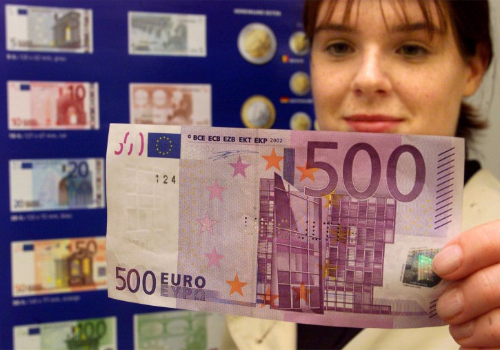 FILE - In this Saturday Sept. 1, 2001 file photo, Aline Heurley from Flensburg looks at a 500-Euro bank note in front of a poster showing the new Euro currency during a public presentation of the new Euro at the branch office of the German Federal Bank in Flensburg, northern Germany.  (AP Photo/Heribert Proepper, File)